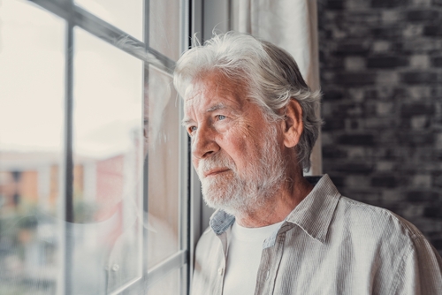 Older man looking out a window